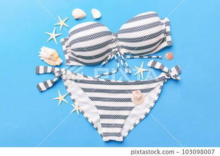 Woman swimwear and beach accessories flat lay top view on colored background Summer travel concept. bikini swimsuit, straw hat and seasheels. Copy space Top view 103098007