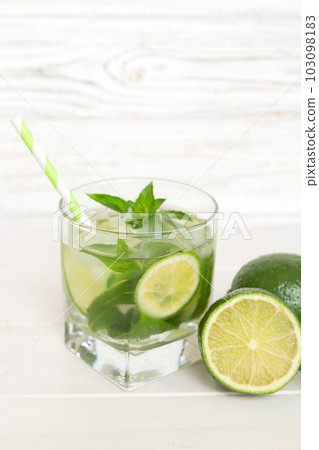 Mojito cocktail. Refreshing mojito cocktail with lime, lemon and mint in a tall glass with a stick 103098183