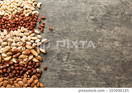 different nuts frame background. Close up, top view, flat lay with vopy space. Walnut, pistachios, almonds, hazelnuts and cashews 103098185