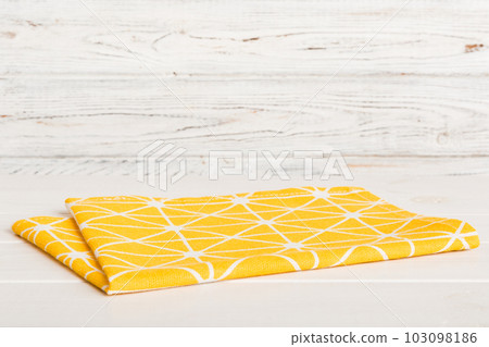 top view with yellow empty kitchen napkin isolated on table background. Folded cloth for mockup with copy space, Flat lay. Minimal style top view with yellow empty kitchen napkin isolated on table background. Folded cloth for mockup with copy space, Flat lay. Minimal style 103098186