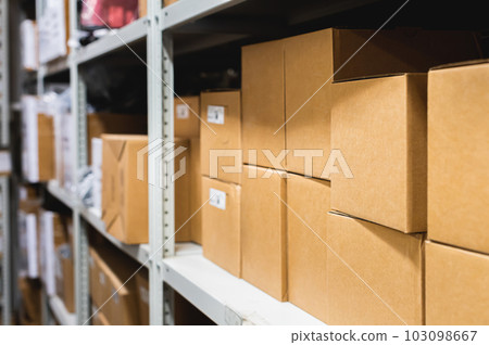 Cardboard boxes lie on racks in a small warehouse. Logistics transportation and delivery of goods 103098667