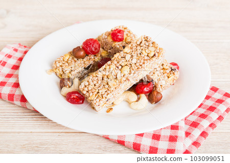 Various granola bars on table background. Cereal granola bars. Superfood breakfast bars with oats, nuts and berries, close up. Superfood concept Various granola bars on table background. Cereal granola bars. Superfood breakfast bars with oats, nuts and berries, close up. Superfood concept 103099051