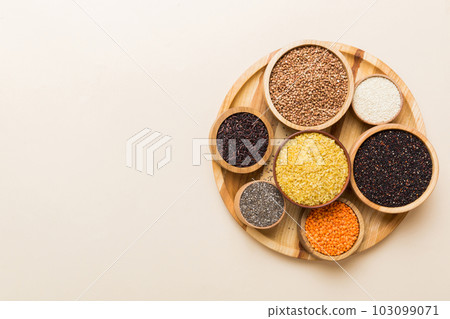 Various superfoods in smal bowl on colored background. Superfood as rice, chia, quinoa, lentils, nuts, sesame seeds, almonds. top view 103099071