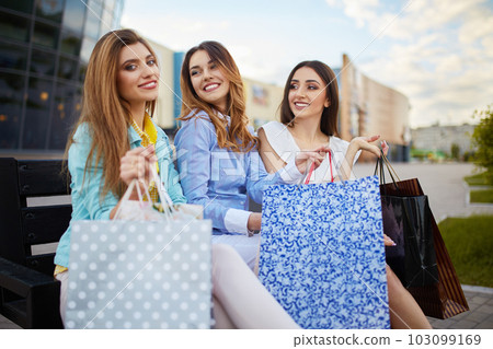 Beautiful girls with packages after shopping. Girl walking around city after shopping. good mood. 103099169