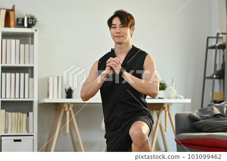 Handsome male athlete in fitness clothes working out in the morning at home. Healthy lifestyle concept Handsome male athlete in fitness clothes working out in the morning at home. Healthy lifestyle concept 103099462