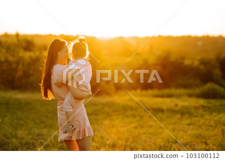 Mother and little daughter playing together in summer sunset. Happy mom with small child having fun. Mother and little daughter playing together in summer sunset. Happy mom with small child having fun. 103100112