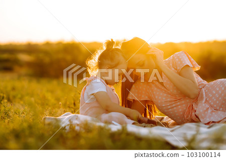 Mother and little daughter playing together in summer sunset. Happy mom with small child having fun. Mother and little daughter playing together in summer sunset. Happy mom with small child having fun. 103100114