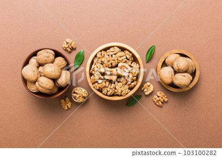 Walnut kernel halves, in a wooden bowl. Close-up, from above on colored background. Healthy eating Walnut concept. Super foods with copy space Walnut kernel halves, in a wooden bowl. Close-up, from above on colored background. Healthy eating Walnut concept. Super foods with copy space 103100282