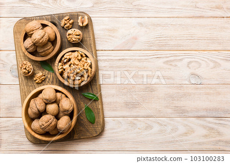 Walnut kernel halves, in a wooden bowl. Close-up, from above on colored background. Healthy eating Walnut concept. Super foods with copy space Walnut kernel halves, in a wooden bowl. Close-up, from above on colored background. Healthy eating Walnut concept. Super foods with copy space 103100283