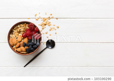 Cooking a wholesome breakfast. Granola with Various dried fruits and nuts in a bowl. The concept of a healthy dessert. Flat lay, top view with copy space 103100290