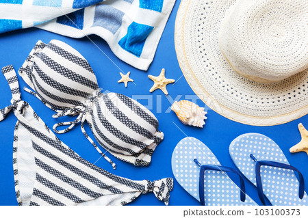 Woman swimwear and beach accessories flat lay top view on colored background Summer travel concept. bikini swimsuit, straw hat and seasheels. Copy space Top view Woman swimwear and beach accessories flat lay top view on colored background Summer travel concept. bikini swimsuit, straw hat and seasheels. Copy space Top view 103100373