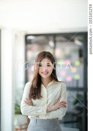 Charming Asian woman with a smile looking to the camera in the office. 103101259
