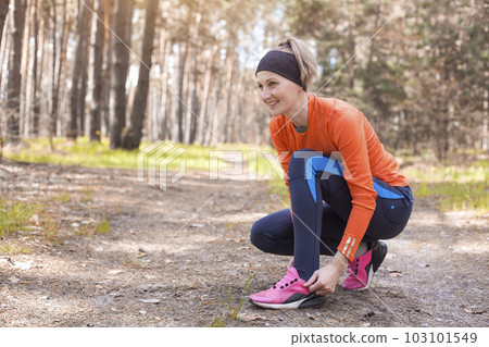 Women Runner tying shoelaces on sneakers. 103101549