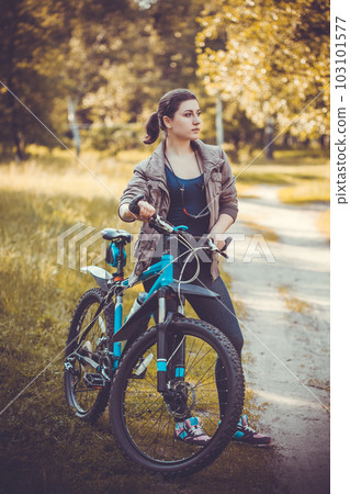woman cyclist rides in the forest on a mountain bike. woman cyclist rides in the forest on a mountain bike. 103101577