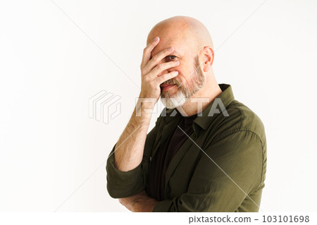 Mature man with silver beard in moment of frustration or disbelief. He puts hand on face in facepalm gesture, conveying sense of sarcasm and exasperation. White background adds emphasis to reaction Mature man with silver beard in moment of frustration or disbelief. He puts hand on face in facepalm gesture, conveying sense of sarcasm and exasperation. White background adds emphasis to reaction 103101698