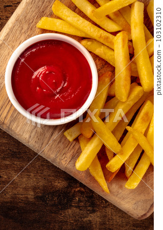 French fries, potato snack with ketchup, fast food on a wooden table 103102310