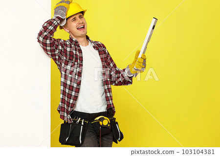 smiling professional builder in work clothes in helmet with level . smiling professional builder in work clothes in helmet with level . 103104381