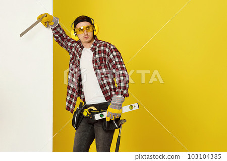 Worker man or builder in construction helmet near white banner Worker man or builder in construction helmet near white banner 103104385