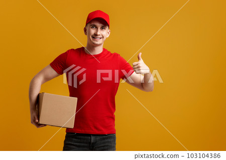 Delivery man employee in red cap, t-shirt holding cardboard box Delivery man employee in red cap, t-shirt holding cardboard box 103104386