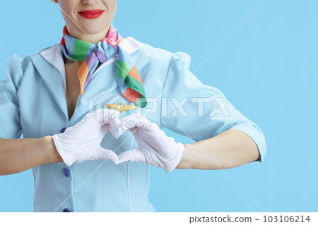Stylish flight attendant woman on blue showing heart hands 103106214