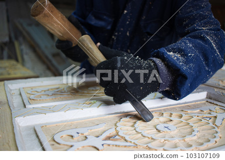 Close Up of Man Hands carving on wooden furniture. Carpenter using tool making Artistic Wood Carving. Producing an Ornament on Wood with Chisel and Hammer on a Panel of Wood . High quality photo Close Up of Man Hands carving on wooden furniture. Carpenter using tool making Artistic Wood Carving. Producing an Ornament on Wood with Chisel and Hammer on a Panel of Wood . High quality photo 103107109