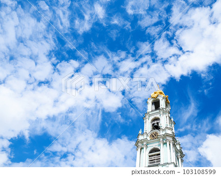 white clouds in blue sky over belfry of church white clouds in blue sky over belfry of church 103108599