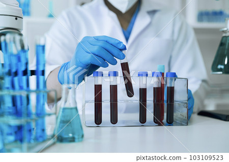 Chemist scientist holding test tube and tablet conducting experiment in laboratory with equipment, science concept. 103109523