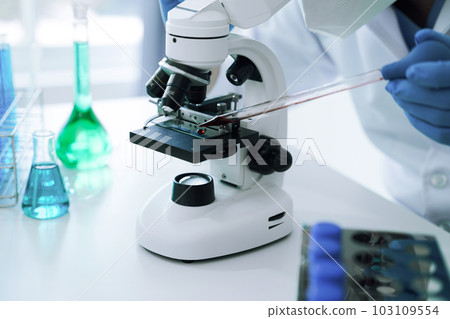 Chemist scientist holding test tube and tablet conducting experiment in laboratory with equipment, science concept. 103109554
