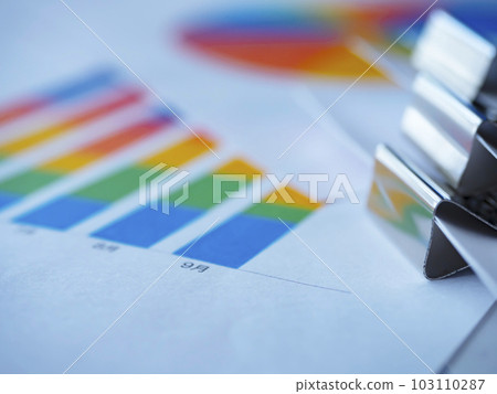 Graphs on the table and documents bound with clips Graphs on the table and documents bound with clips 103110287