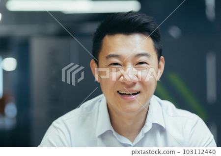Close-up photo of a young Asian businessman, accountant, manager in the office smiling at the camera. Close-up photo of a young Asian businessman, accountant, manager in the office smiling at the camera. 103112440