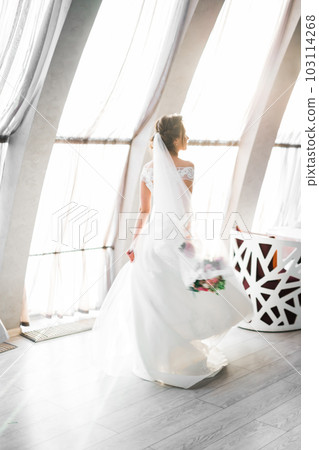 Portrait of stunning bride with long hair posing with great bouquet 103114268