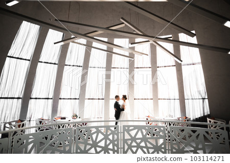 Gorgeous happy couple standing close to each other and looking in eyes Gorgeous happy couple standing close to each other and looking in eyes 103114271
