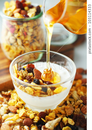 Spread granola on yogurt and sprinkle with honey. Spread granola on yogurt and sprinkle with honey. 103114333