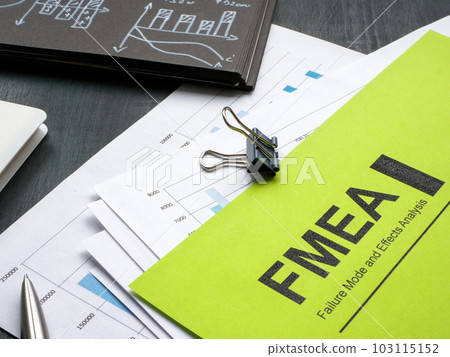 Stack of papers with FMEA failure mode and effects analysis and pen. 103115152