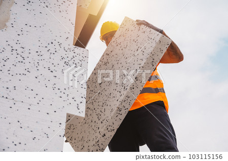 Mason applies glue to a thermal cladding on a construction site Mason applies glue to a thermal cladding on a construction site 103115156