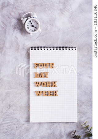 Four day work week concept wooden letters on notebook and alarm clock top and vertical view Four day work week concept wooden letters on notebook and alarm clock top and vertical view 103116846
