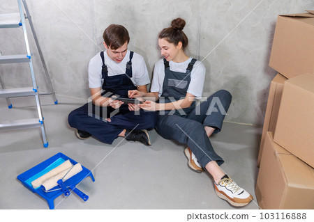 Couple in new home during repair works discussing about home design project looking repair plan on tablet. Happy family choosing new decorations and design. Home renovation DIY renew makeover concept 103116888