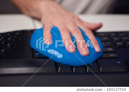 Blue soft gel cleaning dust on keyboard. Concept cleaning your computer's keyboard. Office cleaning. Blue soft gel cleaning dust on keyboard. Concept cleaning your computer's keyboard. Office cleaning. 103117724