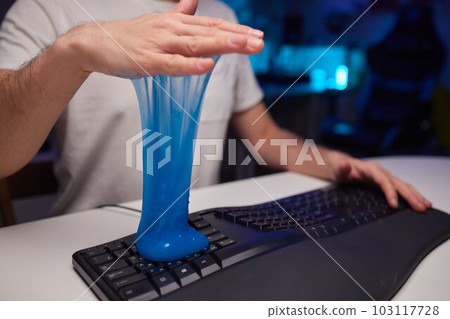 Blue soft gel cleaning dust on keyboard. Concept cleaning your computer's keyboard. Office cleaning. Blue soft gel cleaning dust on keyboard. Concept cleaning your computer's keyboard. Office cleaning. 103117728
