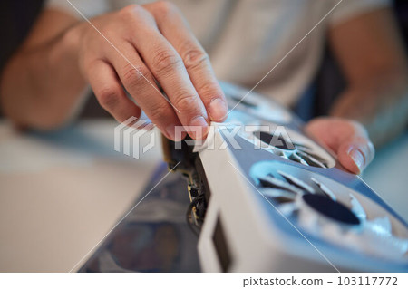Changing the thermal paste on the graphics processor. Disassembled graphics card on the table. Old graphics card service. 103117772