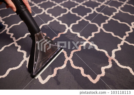 Close-up Of A Person Cleaning Carpet With Vacuum Cleaner. Close-up Of A Person Cleaning Carpet With Vacuum Cleaner. 103118113