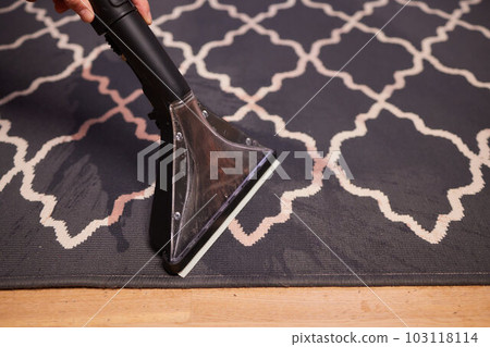 Close-up Of A Person Cleaning Carpet With Vacuum Cleaner. Close-up Of A Person Cleaning Carpet With Vacuum Cleaner. 103118114