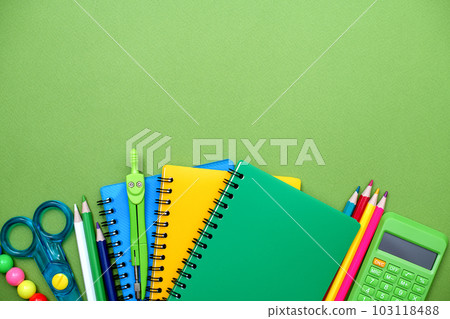Collection different bright school stationery and notebooks on green background, flat lay. Back to school concept 103118488