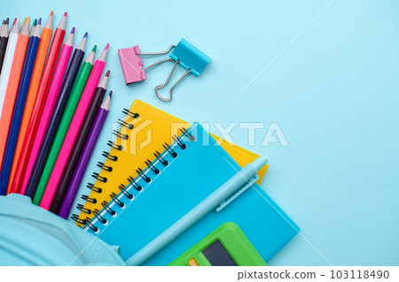 Opened School backpack with stationery on blue background. Organization of the school space. Concept back to school. School supplies Opened School backpack with stationery on blue background. Organization of the school space. Concept back to school. School supplies 103118490