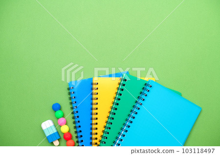 Collection different bright school stationery and notebooks on green background, flat lay. Back to school concept 103118497