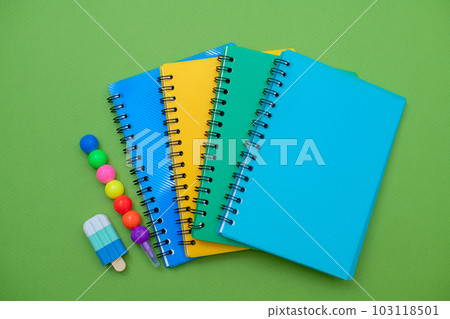 Collection different bright school stationery and notebooks on green background, flat lay. Back to school concept 103118501