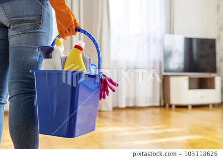 Woman in rubber gloves with bucket of cleaning supplies ready to clean up 103118626