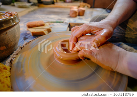 ceramics, workshop, ceramic art concept - close-up of man's hands forming a new vessel, man's fingers working with potter's wheel and raw edge, frontal close-up. 103118799