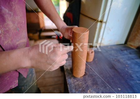 A potter breaks a mala piece into smaller pieces to produce new vessels 103118813