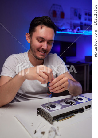 Changing the thermal paste on the graphics processor. Disassembled graphics card on the table. Old graphics card service. Changing the thermal paste on the graphics processor. Disassembled graphics card on the table. Old graphics card service. 103120616